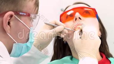 女病人带着医生试图在牙医办公室检查她，牙科护理的概念。 媒体。 一个年轻女孩